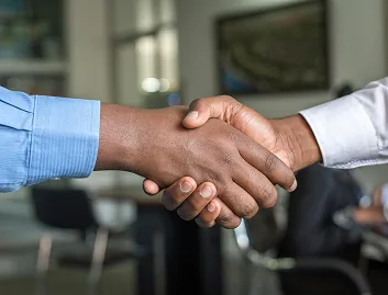 Dos profesionales estrechando sus manos